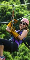 Woman smiling while ziplining through the jungle in Punta Cana