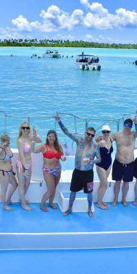 Travelers posing together on a boat near Saona Island